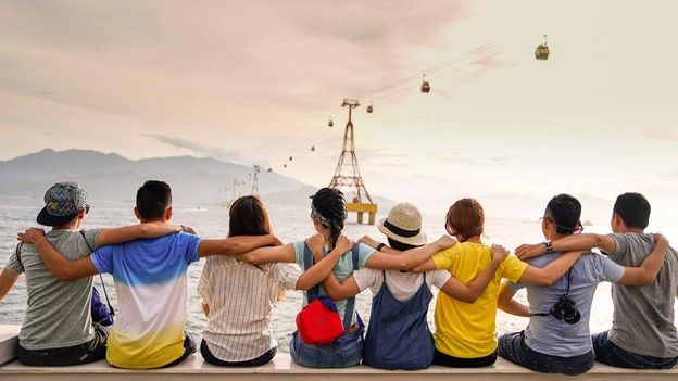 Spanish language students watching the ocean in a group hug