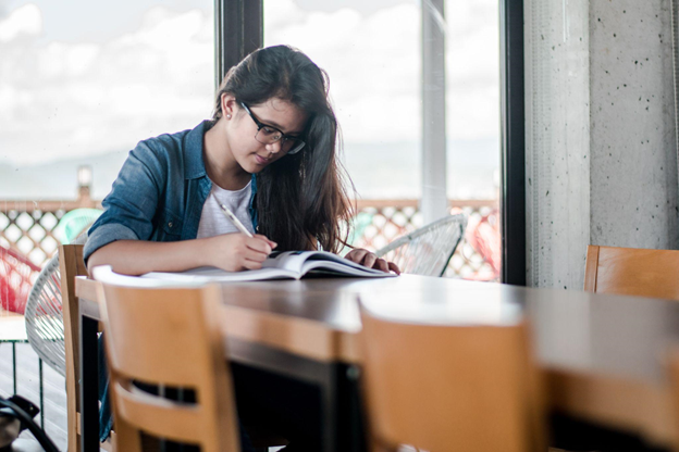 A student doing multiple languages exercises on her textbook 